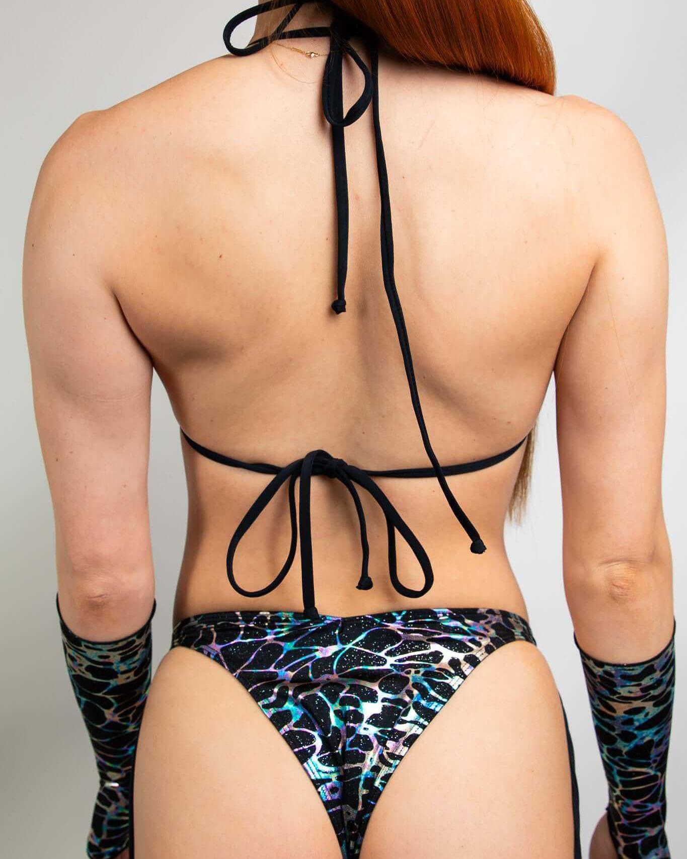 Woman modeling Galactica Strappy Bikini Top with black and oil slick design, perfect for rave outfits and summer fun.