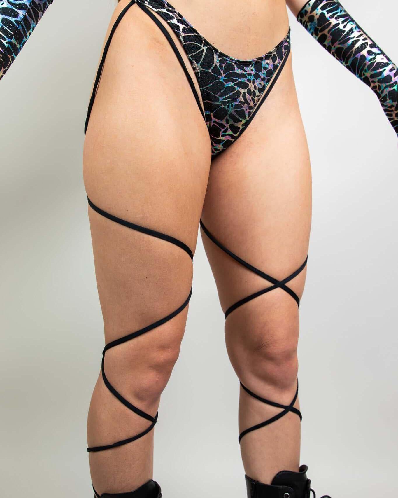 Galactica High Hip Strappy Bottoms feature a unique black and oil slick design, perfect for stylish rave outfits.