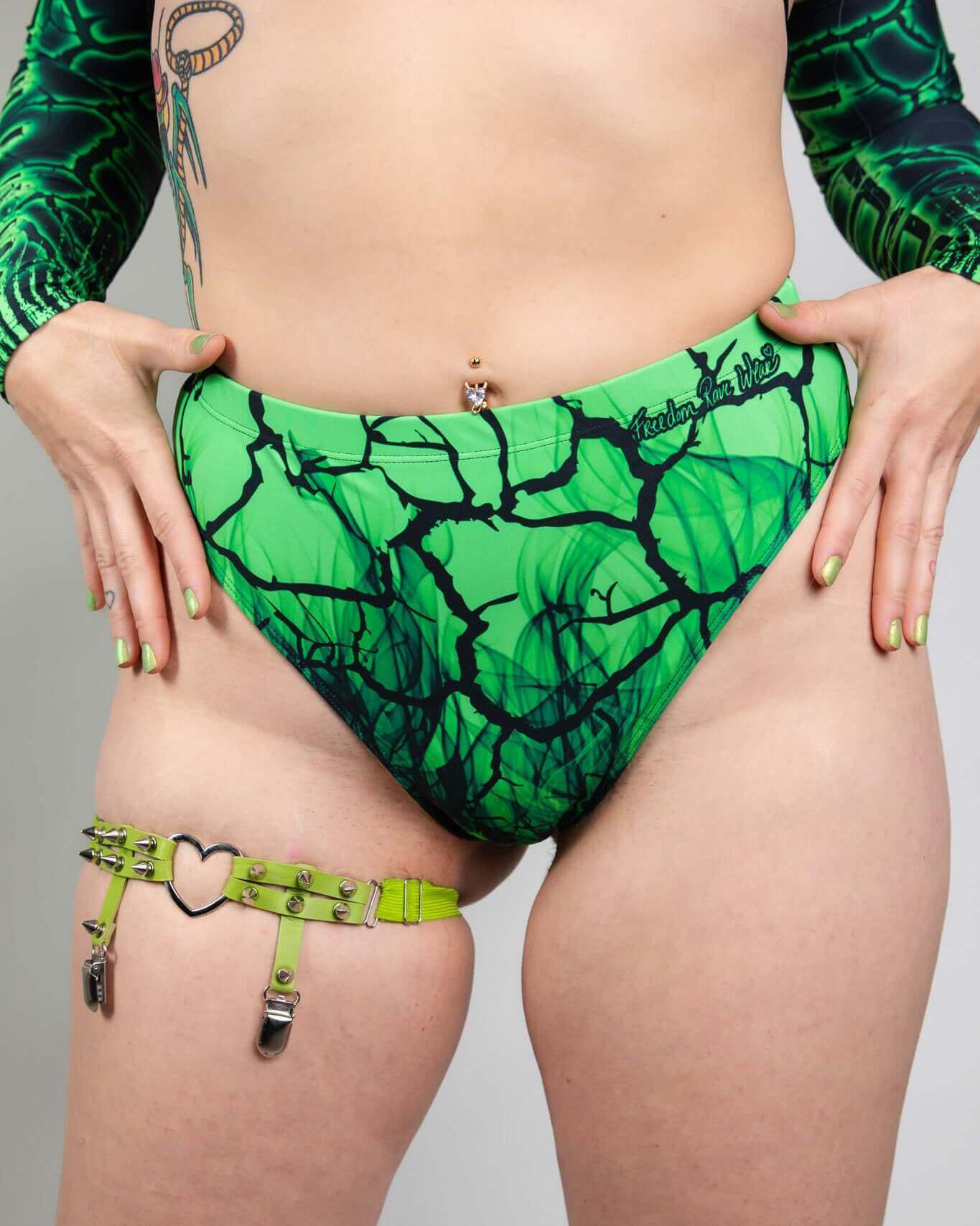 High waisted green Brazilian bottoms with a toxic design, perfect for festival rave outfits and made from recycled materials.