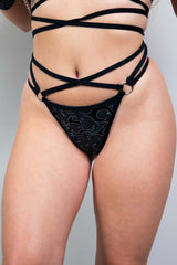 Black holographic rave thong with strappy design and metal rings by Freedom Rave Wear, perfect for festival outfits.