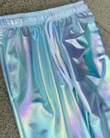 Close-up of Frost Lucy Pants fabric in iridescent blue, green, and violet tones, showcasing high-waisted design and shimmering material, perfect for rave fashion and festival style.