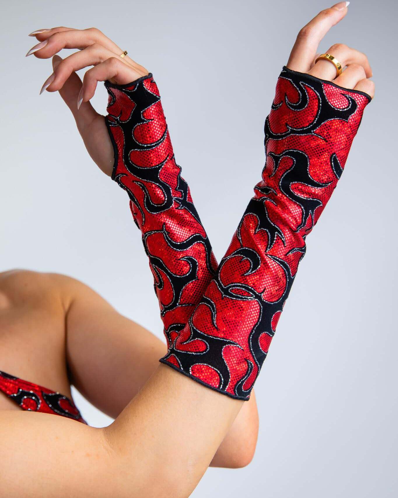 Inferno Gloves in red and black flame design, perfect for rave outfits, showing stylish over-the-wrist design and thumb holes.