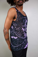 An up close photo of a man wearing a black mesh tank top with purple tattoo-like designs. He is facing to the right.