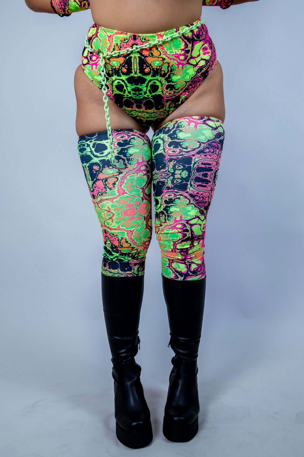 Model wearing Intensity Leg Sleeves with a funky UV reactive pattern, ideal for rave outfits and stylish gym wear.