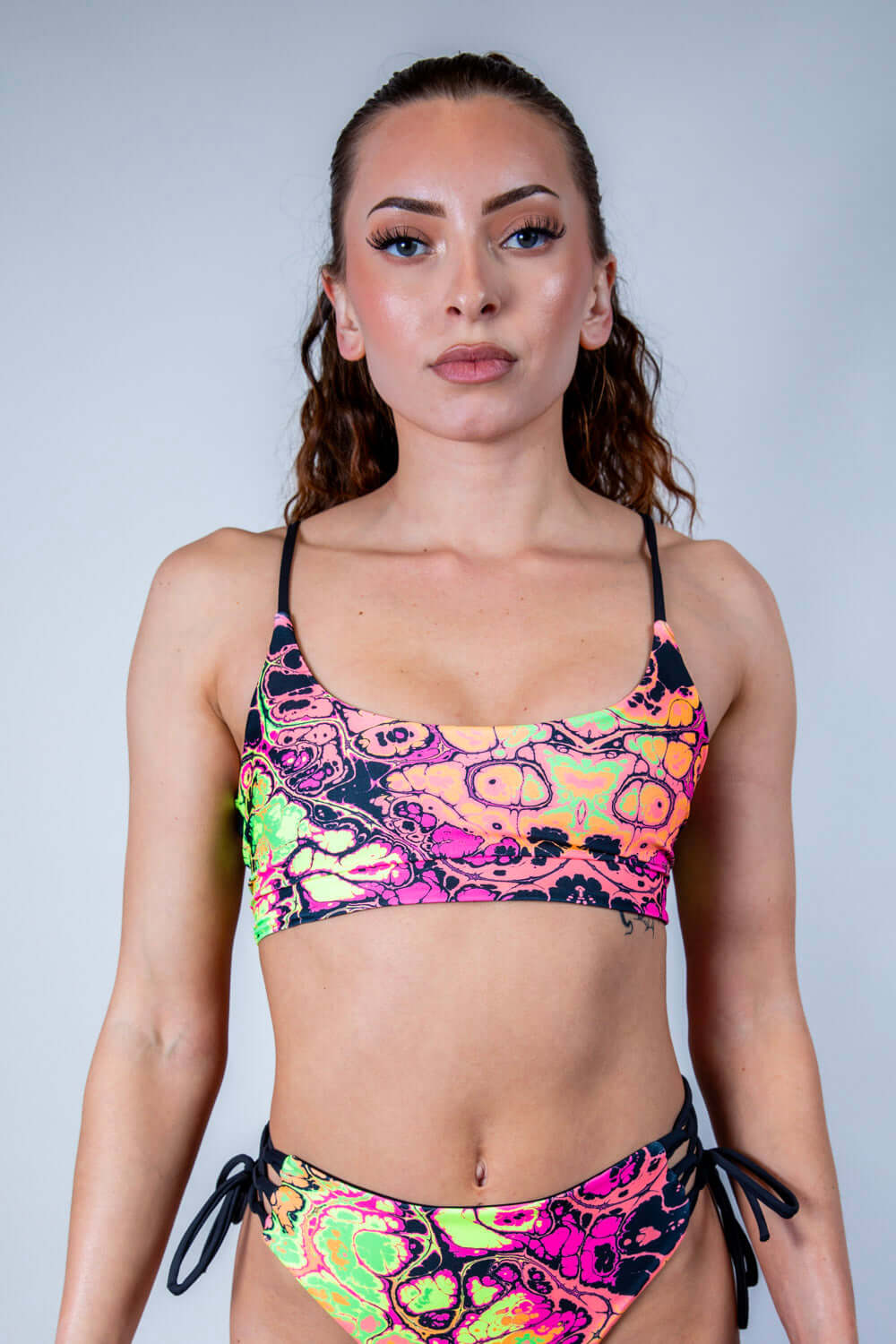 Model wearing Intensity Reversible Lush Top in vibrant UV reactive colors, perfect for rave outfits and stylish looks.