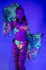 Model showcasing vibrant Intensity Mesh Bell Sleeves with UV reactive patterns, perfect for rave outfits.