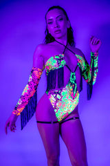 Model wearing Intensity Twist Bodysuit with fringe in UV light, showcasing bold colors perfect for rave outfits.