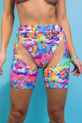 An up close photo of a woman wearing short chaps with a rainbow design and matching bikini bottoms.