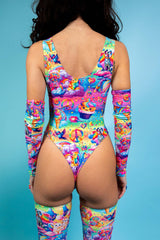 A woman wearing a rainbow bodysuit with whimsical characters on it. She is facing away from the camera.