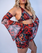 Front view of Lacewing Metamorphosis Sleeves in red and black gothic butterfly print, worn by a model at a rave.