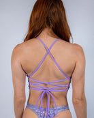 Back view of a lavender holo V top with lace-up detail, perfect for rave outfits and festival fashion.