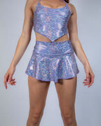 Model wearing lavender holographic rave skirt set with matching crop top, front view against white background