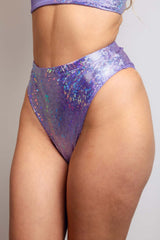 Side profile view of a model wearing a shimmering lavender rave high waisted bottoms from Freedom Rave Wear.
