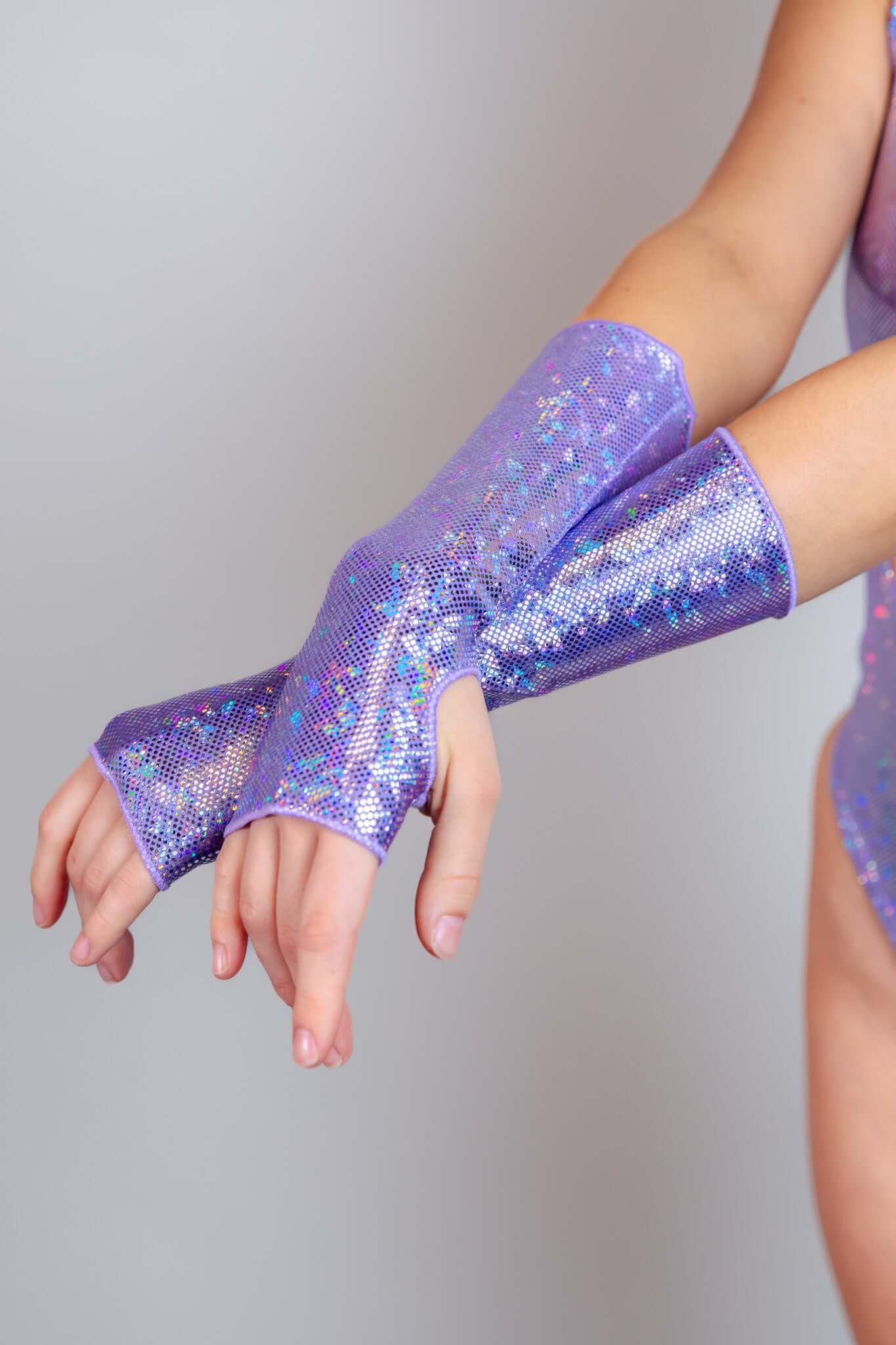 Close-up of a model's arm wearing a sparkling lavender glove, accentuating a dazzling sequined finish from Freedom Rave Wear