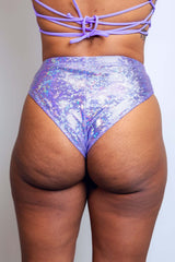 Rear view of a model in sparkling lavender high-waisted bottoms from Freedom Rave Wear, featuring an intricate lace-up back