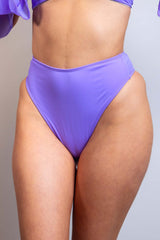 Close-up front view of a model wearing a lavender high-waisted thong, showcasing sleek, minimalistic design from Freedom Rave Wear