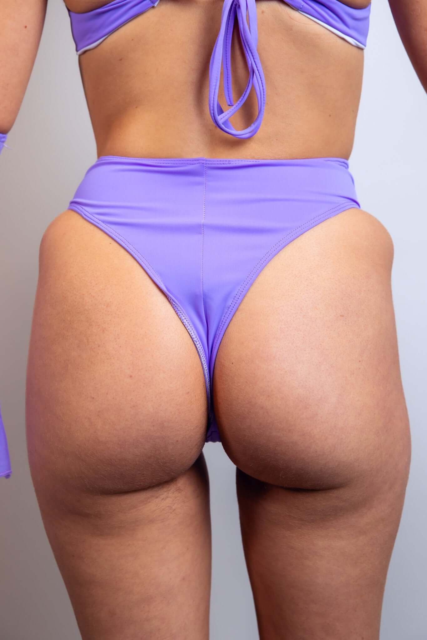 Rear view of a model in Lavender Love high-waisted rave bottoms, part of Freedom Rave Wear's collection