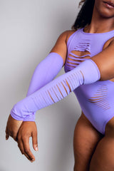 Woman posing in a lavender Freedom Rave Wear slit bodysuit, complemented by matching arm sleeves featuring detailed cut-out