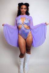 Lavish lavender bodysuit paired with flowing mesh bell sleeves and sparkly boots, a standout piece from Freedom Rave Wear.