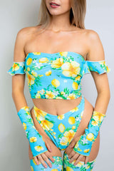 Woman in a blue floral off-the-shoulder Bardot top, showcasing a vibrant summer style perfect for rave outfits.