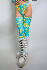 Model wearing Lemon Drop Leg Sleeves with floral print, paired with stylish white boots, perfect for rave outfits.