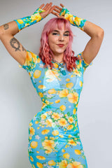  Model in a floral mesh dress from Freedom Rave Wear: blue and yellow full-length dress with matching sleeves, showcasing vibrant floral patterns.