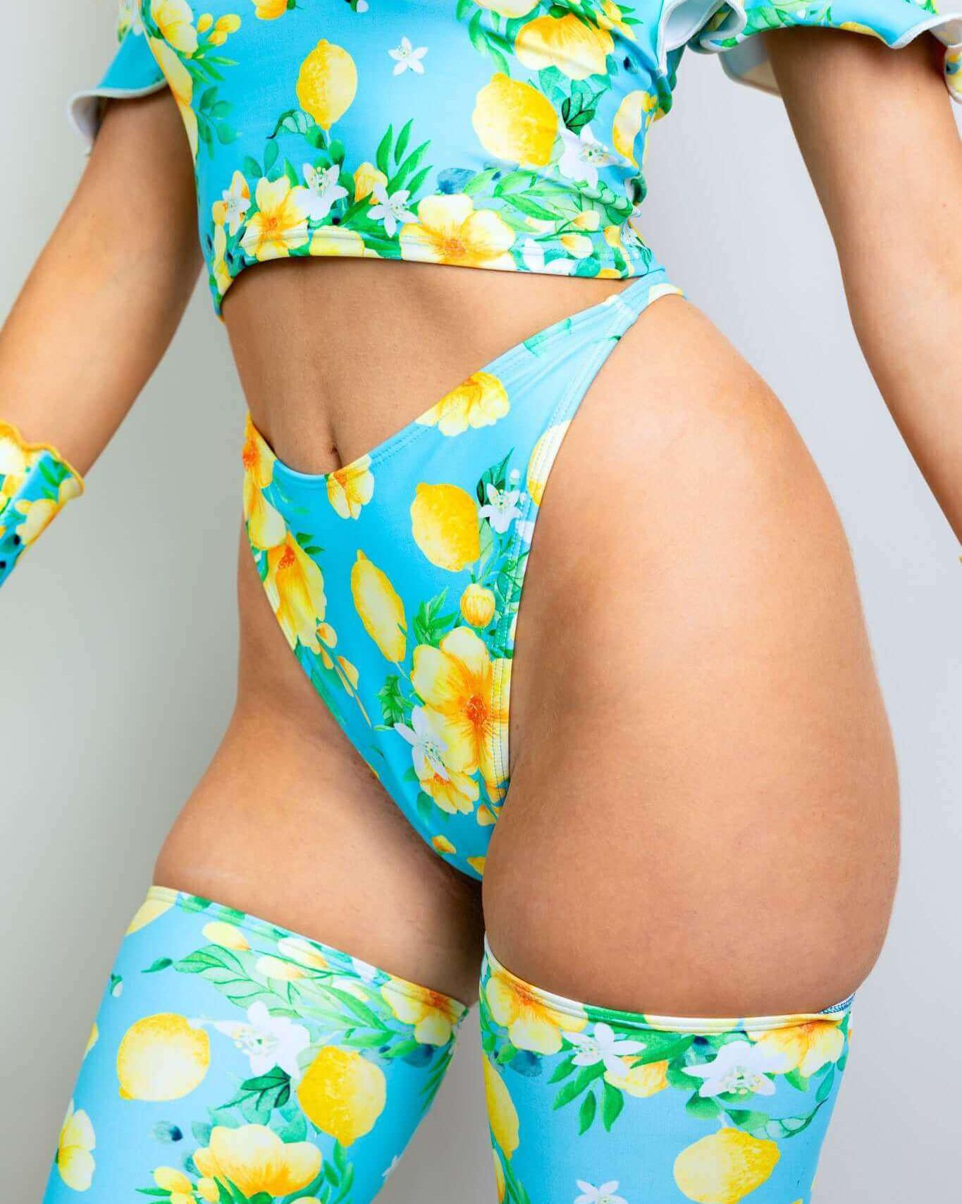 Model showcasing Lemon Drop Retro Thong Bottoms with playful lemon print, perfect for stylish rave outfits.