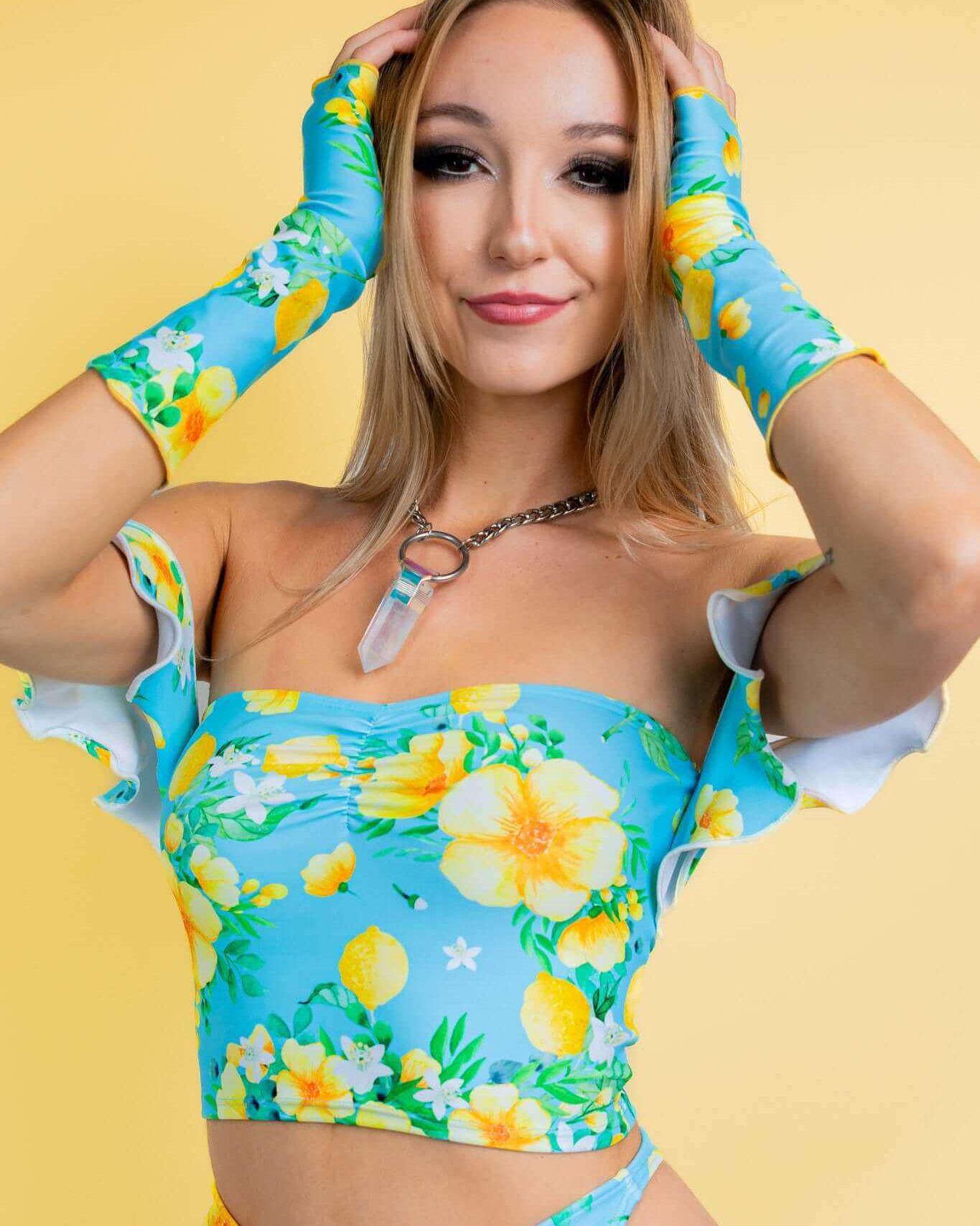 Model showcasing Lemon Drop Gloves with floral rave outfit against a bright yellow background. Perfect for summer rave outfits.