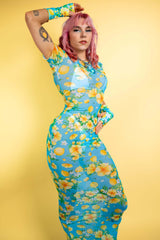 Model in a floral mesh dress from Freedom Rave Wear: blue and yellow full-length dress with matching sleeves, showcasing vibrant floral patterns.