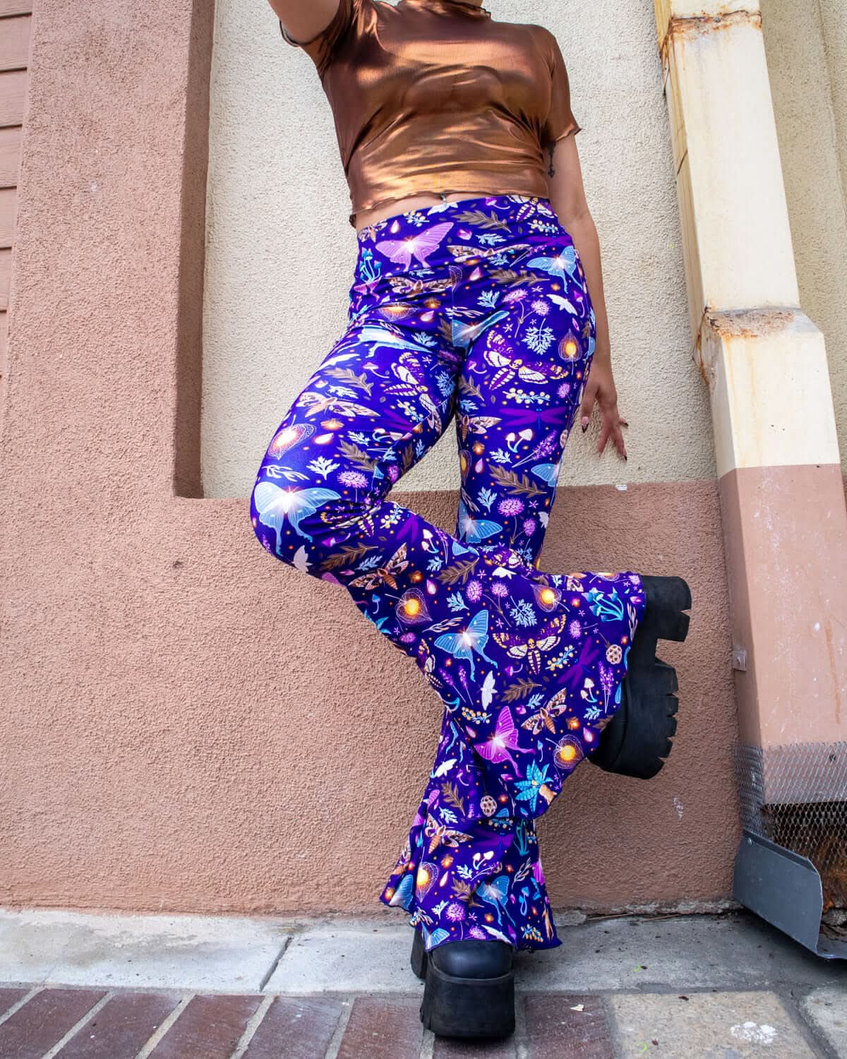 Lucent Bell Bottoms featuring a vibrant bioluminescent print, styled with a metallic top for trendy rave outfits.