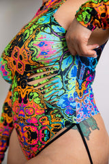 Front view of a vibrant Freedom Rave Wear bodysuit with colorful psychedelic patterns, paired with black strappy details