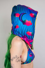 Side view of a model in Freedom Rave Wear's vibrant, wavy-patterned hood, showcasing a unique and stylish accessory for festival outfits.