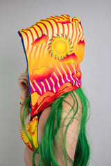 Side view of a model wearing a Freedom Rave Wear vibrant hood featuring a sunset-inspired print, perfect for enhancing any festival attire.