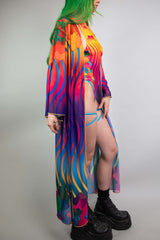 Side view of a vibrant Freedom Rave Wear robe featuring a flowing design with sun and wavy patterns, styled over a bikini