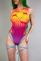 Freedom Rave Wear's vibrant bodysuit features a sun motif and mesmerizing stripes, highlighted by striking blue strap details.
