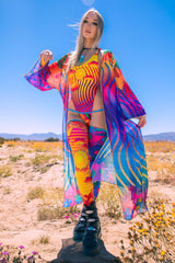Freedom Rave Wear ensemble with a vibrant robe and matching accessories worn by a woman in a sunlit desert