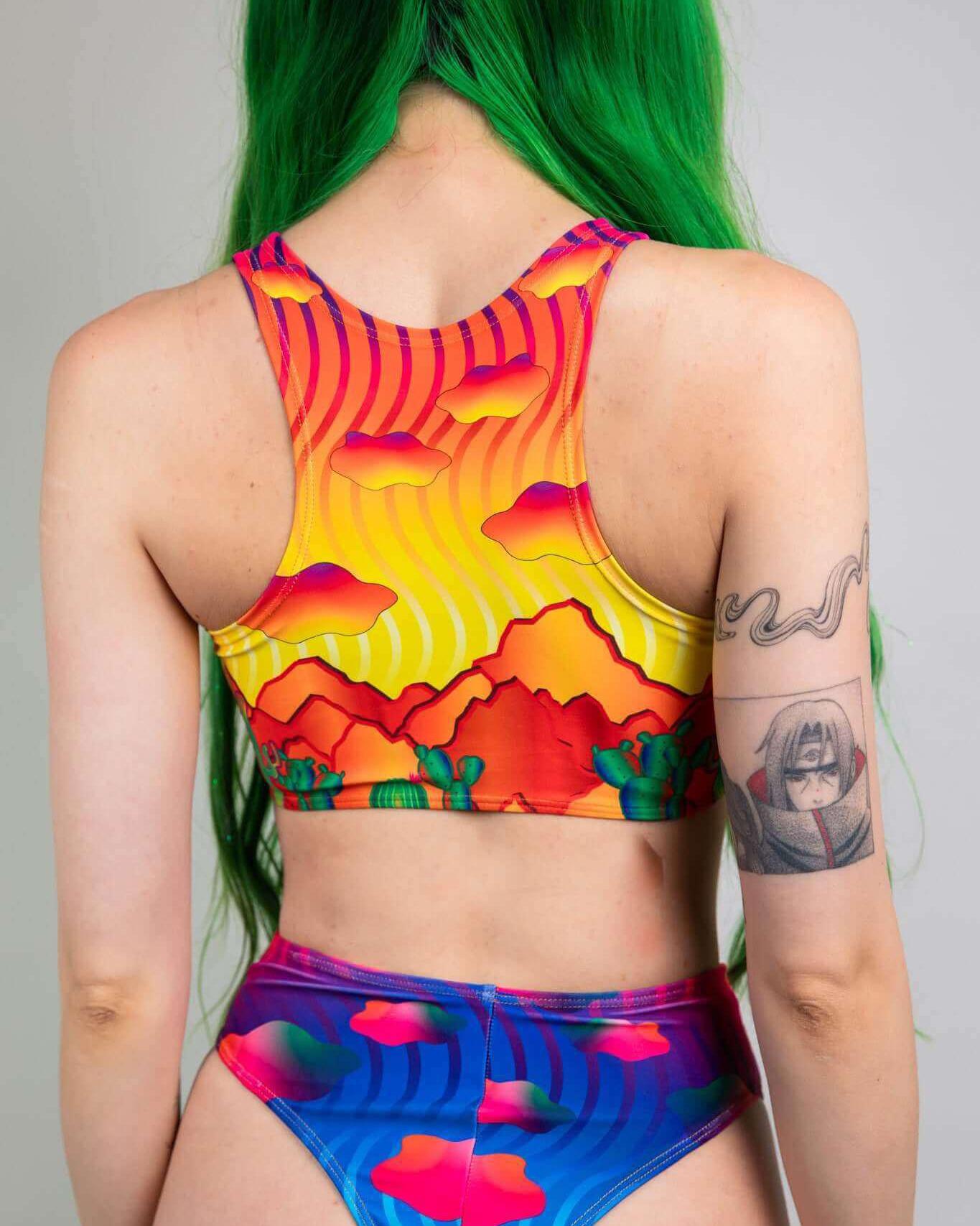 Model showing the back of the vibrant Mirage Teaser Top, a stylish rave outfit with colorful desert print.