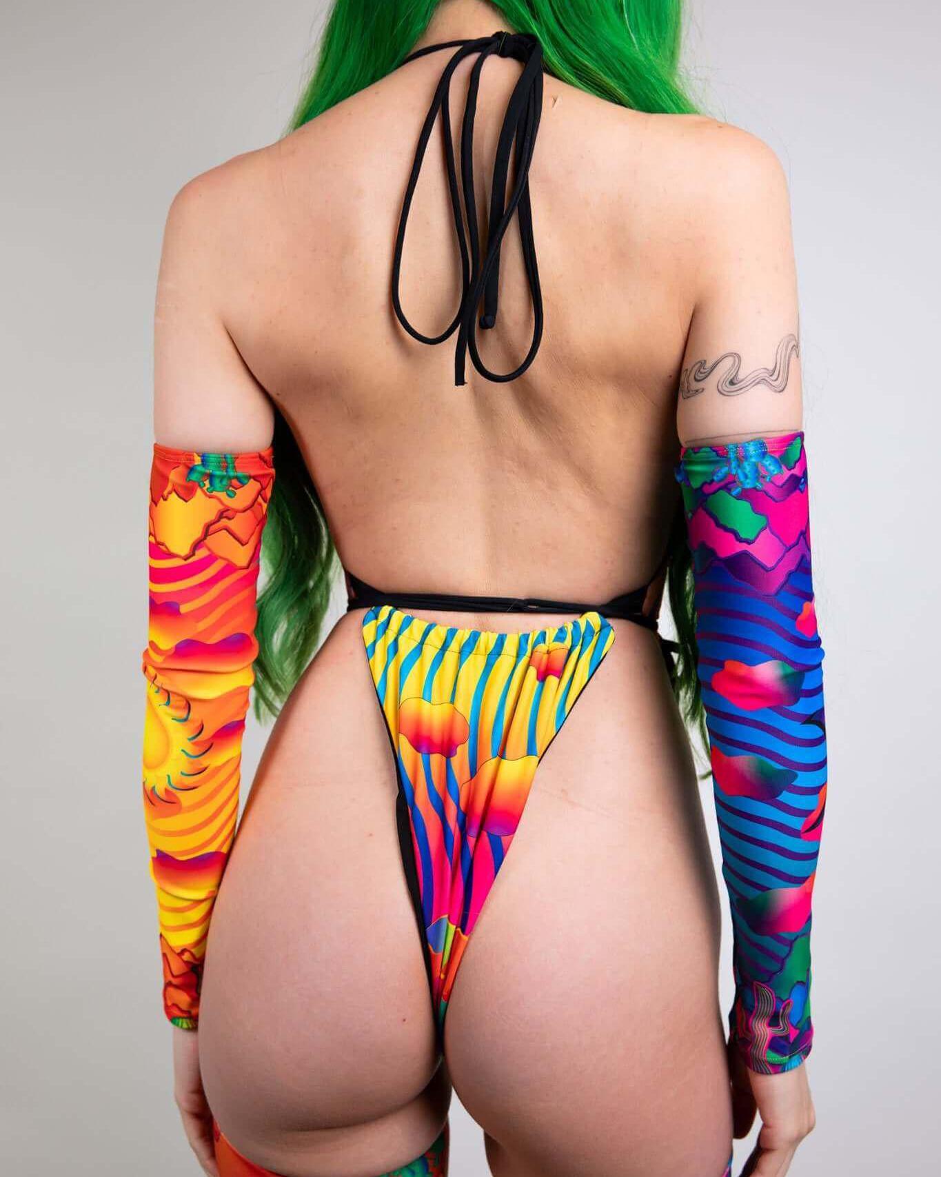 Colorful back view of a model wearing a vivid, long-sleeve bodysuit with striking patterns and a high-cut design.