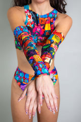 A photo of a girl's arms, wearing rainbow patchwork sleeves.
