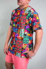 A man posing in a rainbow patchwork t-shirt and pink shorts.