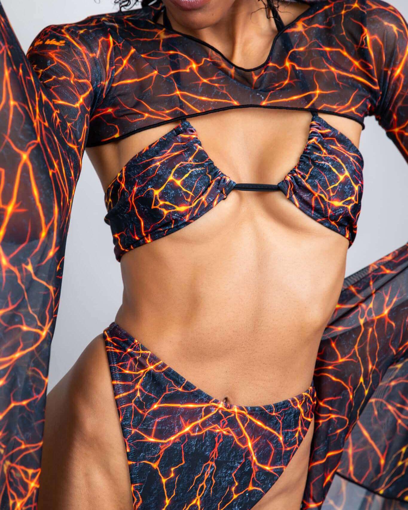 Model showcasing the Magma Twist Tie Bandeau Top with fiery lava-inspired print, perfect for rave outfits.