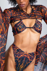 Model showcasing the Magma Twist Tie Bandeau Top with fiery lava-inspired print, perfect for rave outfits.