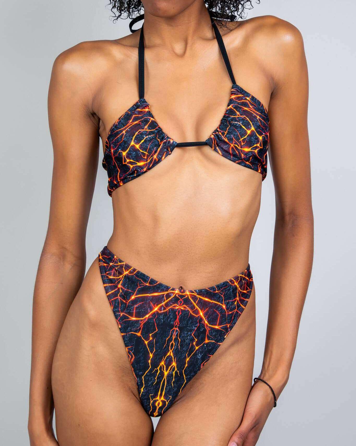 Model showcasing the Magma Twist Tie Bandeau Top, featuring a fiery lava print, perfect for rave outfits.