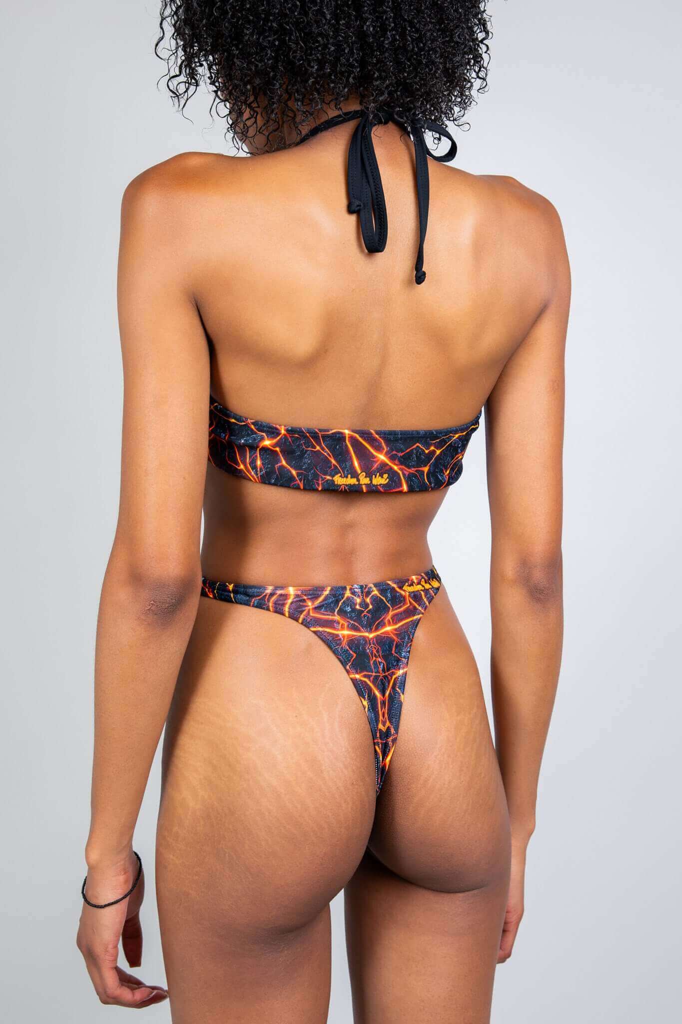 Freedom Rave Wear bikini showcasing a lava print. Halter top and high-cut thong bottoms designed for an eye-catching festival appearance.