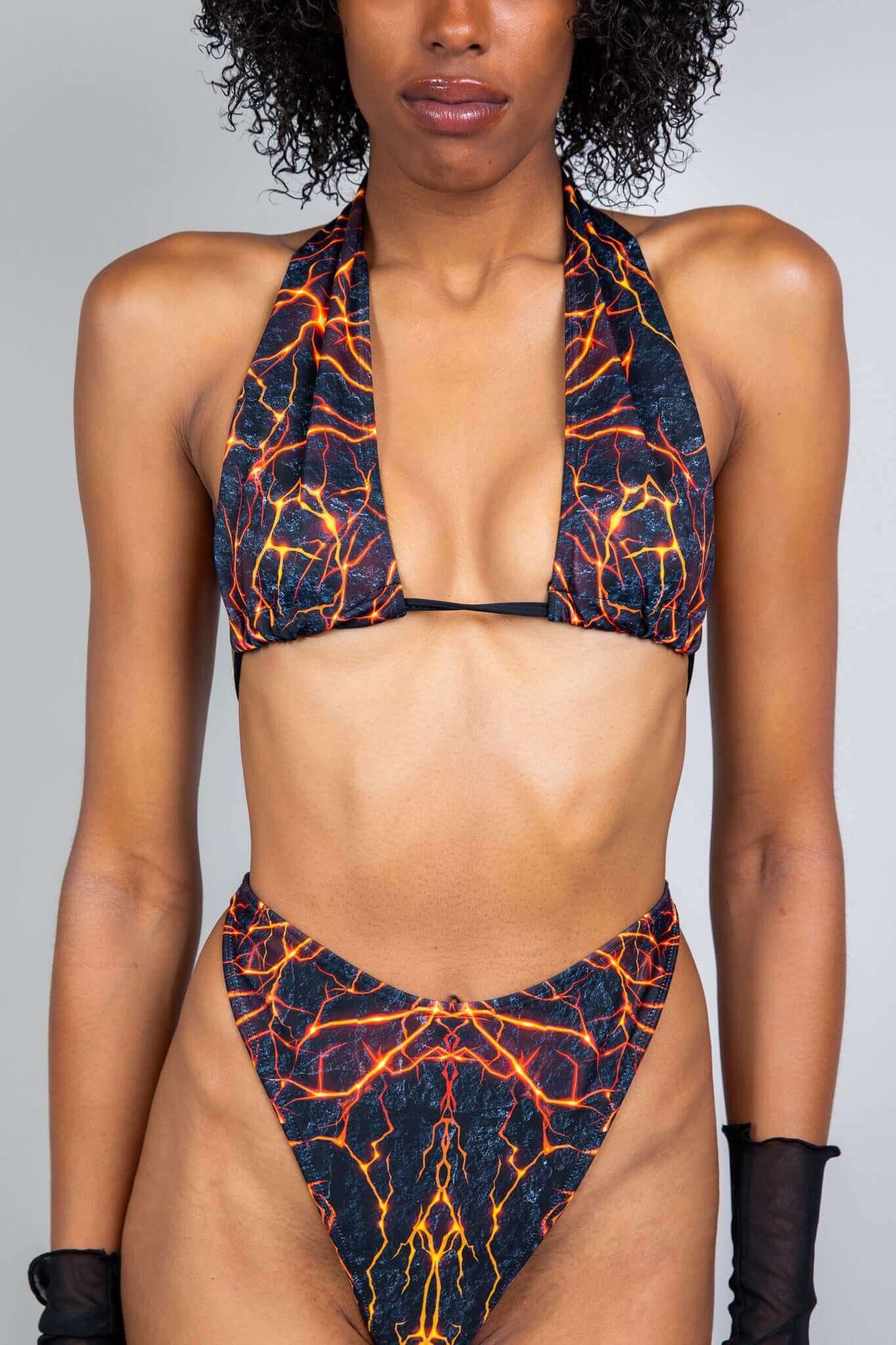 Freedom Rave Wear bikini with a bold lava print. Features a halter top and high-cut thong bottoms, designed for a striking look at festivals.