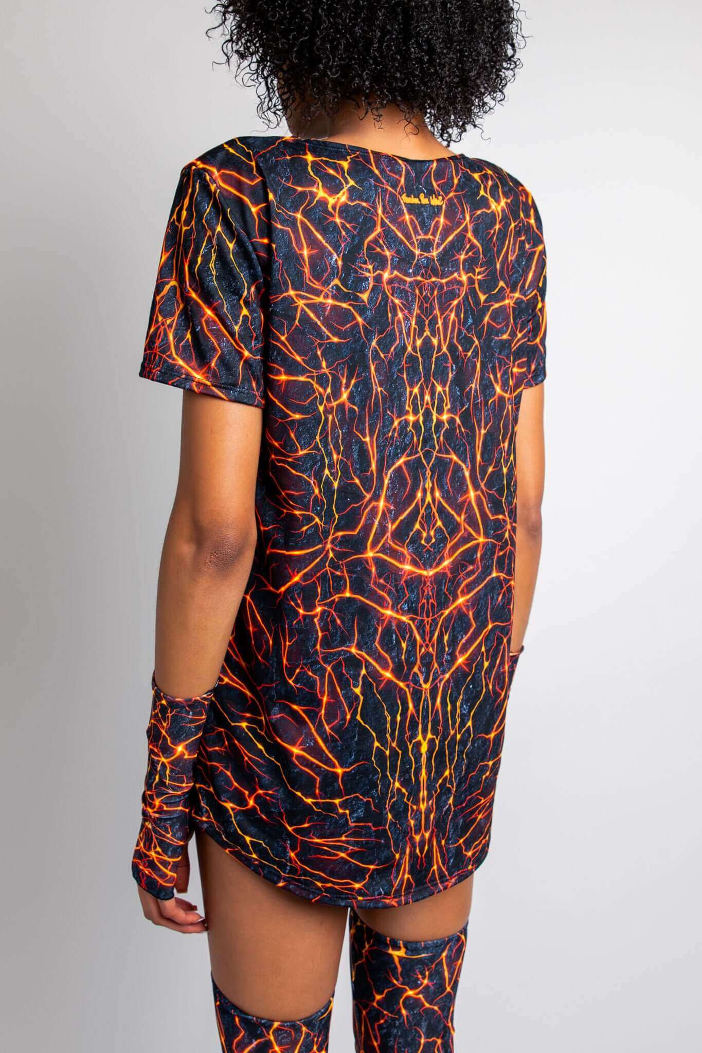 Back view of a model wearing a Freedom Rave Wear t-shirt dress with a vivid lava print and matching arm sleeves