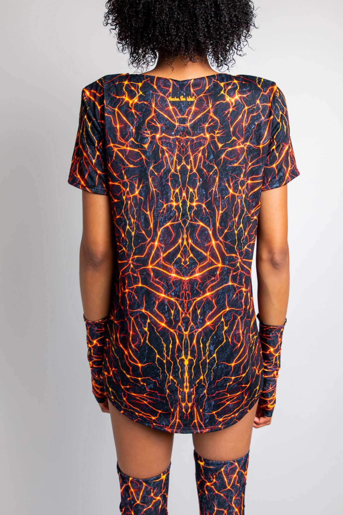 Back view of a model wearing a Freedom Rave Wear t-shirt dress with a vivid lava print, matching arm sleeves, and leg warmers.