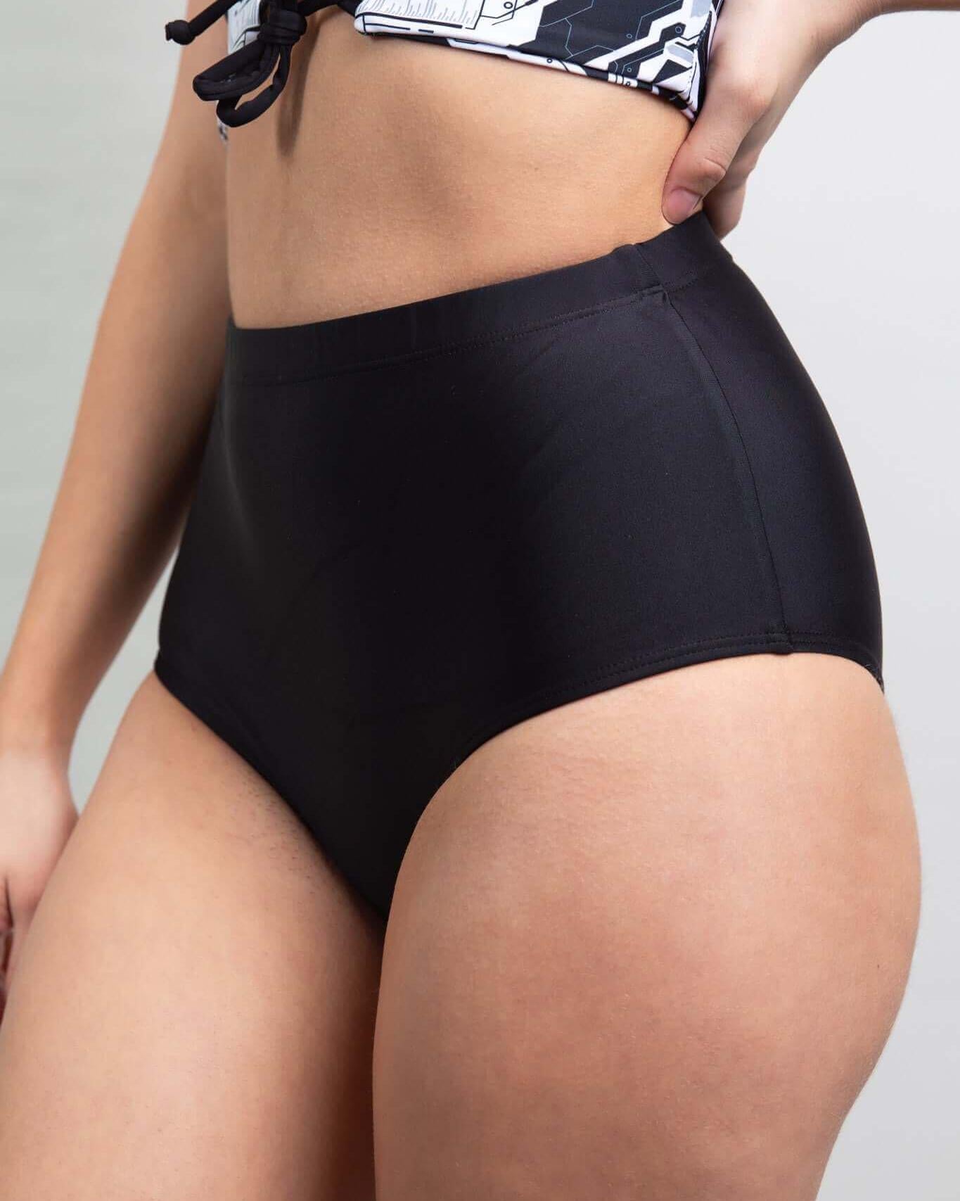 Matte black high waisted bottoms for women, perfect for rave outfits, showcasing soft, stretchy design and added coverage.