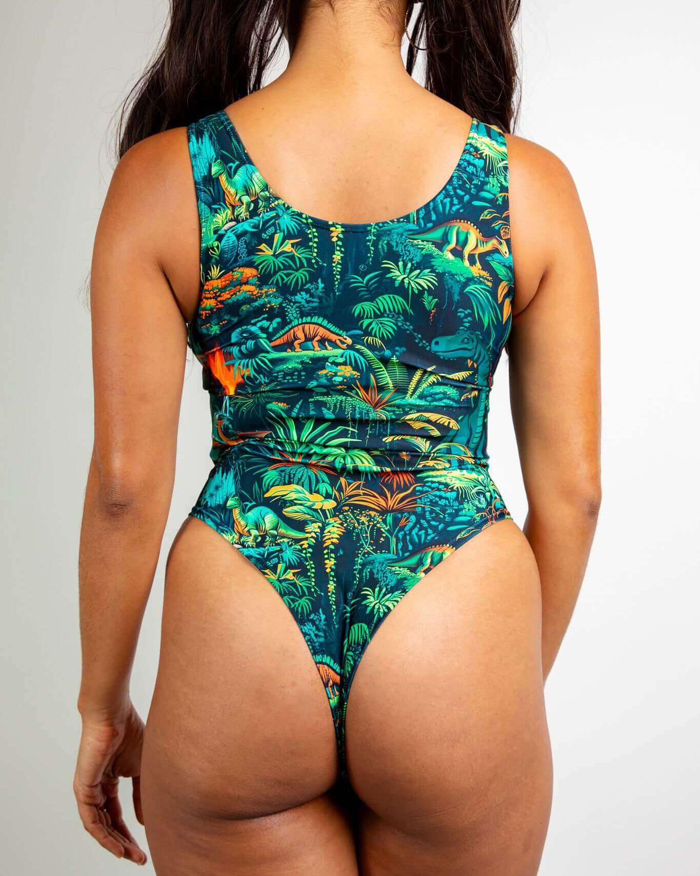 Mesozoic Classic Bodysuit with vibrant dinosaur print, showcasing scoop neck design and thong back for rave outfits.