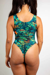 Mesozoic Classic Bodysuit with vibrant dinosaur print, showcasing scoop neck design and thong back for rave outfits.